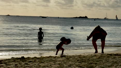 Eine-Mutter-Versucht,-Ihren-Sohn-Bei-Sonnenuntergang-Am-Strand-Zu-Fotografieren