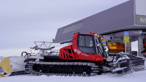 Red-snowcat-next-to-a-ski-lift-station-on-top-of-the-mountain