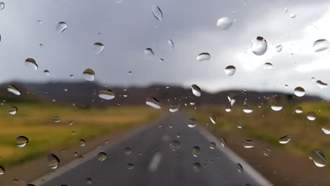 Driving-in-road-in-mountain-nature-and-passing-winding-lanes-way-in-rural-landscape-and-cloudy-sky-with-drizzle-rain-and-blur-landscape
