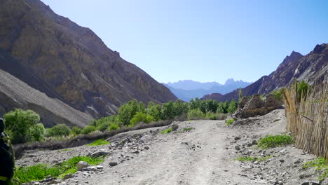 Happy-tourist,-a-backpacker-walking-on-the-Markha-Valley-Trek-in-the-Himalayas-on-a-sunny-day