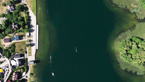 Luftaufnahme:-Ansicht-Von-Oben-Nach-Unten-Von-Kanus,-Die-Auf-Der-Oberfläche-Des-Grünen-Sees-In-Trakai-Fahren
