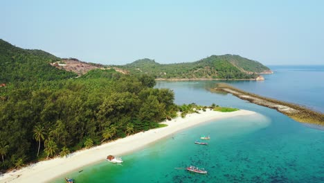 Thailand,-Aerial---pristine-nature,-white-sand-beach,-palm-trees-and-turquoise-seawater-with-boats