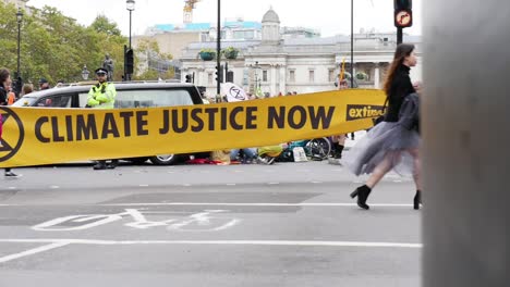 Eine-Gleitende-Zeitlupenaufnahme-Zeigt-Das-Gelbe-Schild-„Climate-Justice-Now“-Während-Der-Extinction-Rebellion-Proteste-In-London