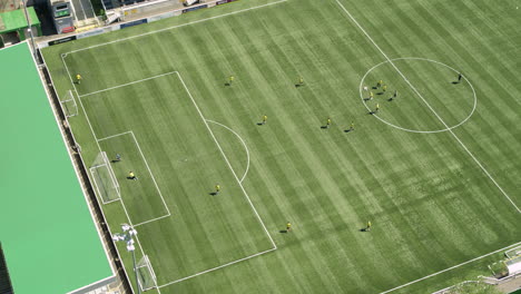 Wide-aerial-establishing-shot-of-Maidstone-FC,-players-training-on-the-pitch-with-a-scored-goal
