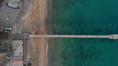 Top-down-view-of-a-bridge-leading-into-the-ocean-by-Porto-Santo