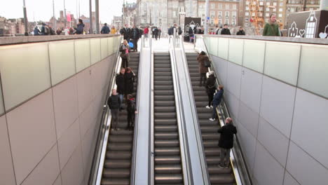Menschen-Auf-Der-Rolltreppe-Betreten-Und-Verlassen-Den-Amsterdamer-Hauptbahnhof-In-Amsterdam,-Nordholland,-Niederlande