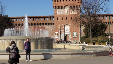Sforzesco-castle-main-tower-front-plazza-with-people-hanging-out-and-taking-photos-during-bright-sunny-day-in-Milan-Italy