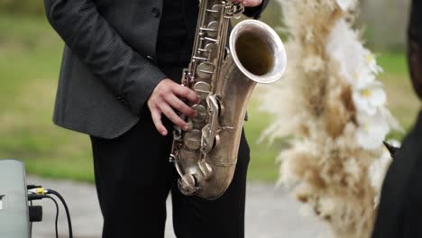 Nahaufnahme-Von-Saxophonisten-Im-Schwarzen-Anzug,-Die-Bei-Der-Hochzeit-Goldenes-Saxophon-Spielen