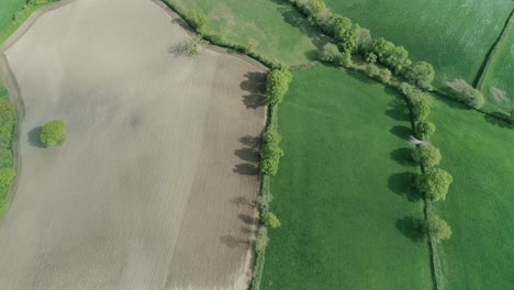 Aerial-view-over-agricultural-region-of-Britain,-demonstrating-different-textures-and-colors-from-various-land-uses