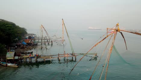 Landscape-of-traditional-Chinese-fishing-nets-in-India-Kerala-Kochi-fort-Cochin-land-mark-viewpoint-is-a-touristic-area-to-buy-from-fish-market,-sea-food-restaurant-and-fishing-experience