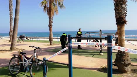 Man-Arguing-With-A-Local-Policemen-While-Putting-Tape-Around-The-Gym-Equipments-To-Prevent-The-Public-Using-It-During-The-Coronavirus-In-Malaga,-Spain
