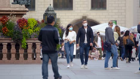 Ein-Paar-Geht-Mit-Gesichtsmasken-Durch-Die-Münchner-Innenstadt,-Um-Sich-Vor-Dem-Coronavirus-Zu-Schützen