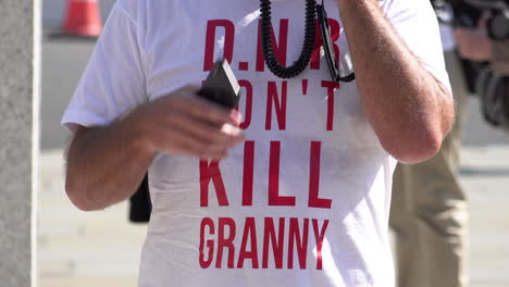 Un-Manifestante-En-Una-Protesta-De-Conspiración-De-Coronavirus-Usa-Una-Camiseta-Roja-Y-Blanca-Que-Dice,-&quot;d