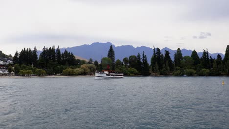 Wide-shot-of-famous-TSS-Earnslaw-ship-sailing-into-harbour-on-Lake-Wakatipu,-Queenstown-Otago,-New-Zealand
