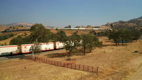 Vista-Aérea-De-Los-Trenes-Que-Pasan-Sobre-Las-Montañas-En-Tehachapi-California