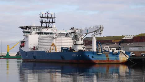Ein-Großer-Blau-weißer-Schiffscontainer-Wird-In-Einem-Kleinen-Dock-Abgeladen