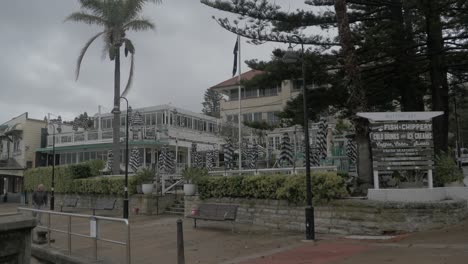 Adult-Man-Walking-At-Beach-Promenade-Passing-By-The-Watsons-Bay-Boutique-Hotel---Coronavirus-Pandemic---Sydney,-NSW,-Australia