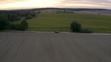 Volkswagen-Touareg-car-driving-on-a-country-dirt-road-between-fields-in-Czechia