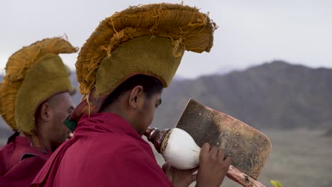 Tibetan-Buddhist-Monks-blow-Shankha-Conch-Shells-early-in-the-morning-at-a-monastery-in-Ladakh,-India