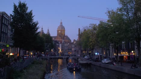 Basiliek-van-de-Heilige-Nicolaas-filmed-from-Korte-Niezel,-the-Canal-of-Oudezijds-Voorburgwal-in-the-foreground