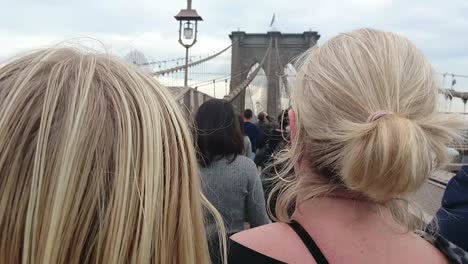 Blonde-female-tourists-on-Brooklyn-Bridge,-Manhattan,-New-York