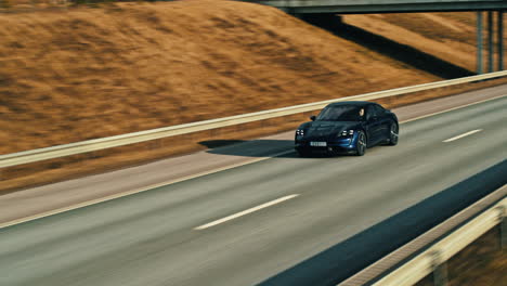 Blue-Porsche-Taycan-driving-on-highway