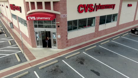 CVS-pharmacy-drugstore-chain-in-United-States-of-America,-woman-wearing-masks-buys-prescription-drugs,-pandemic-and-immunization-coronavirus-COVID-theme