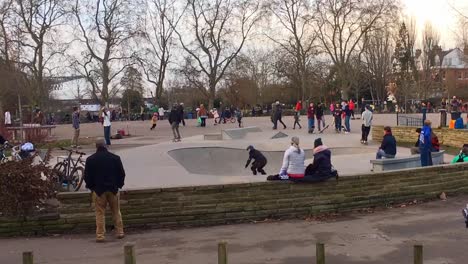 Youths-and-children-skateboard-in-a-playground-in-a-London-park---time-lapse