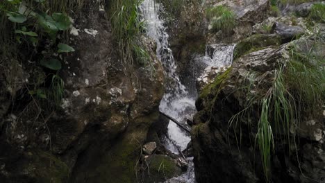 Wasser-Plätschert-Auf-Moosigen-Felsen-Am-Gebirgsbach-Wasserfall