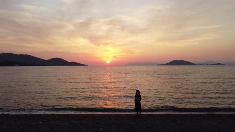 Girl-in-a-peaceful-moment-watching-the-famous-sunset-in-Calis-Beach,-Fethiye---Turkey