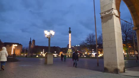 POV-walking-towards-beautiful-christmas-lights,-decorations-and-statues-during-winter-at-Schlossplatz-in-Stuttgart,-Germany