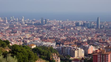 Panning-panoramic-shot-over-polluted-barcelona-skyline,-famous-mediterranean-city-in-Spain
