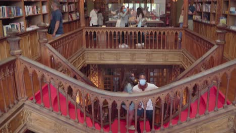 Masked-tourists-visit-the-Livraria-Lello-in-Porto,-during-the-COVID-19-pandemic