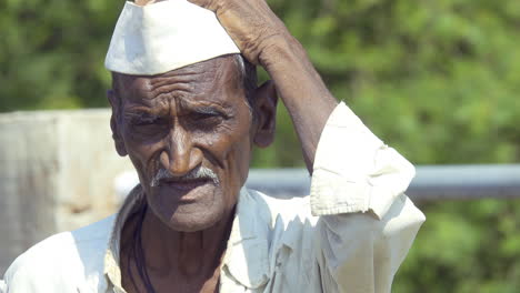 Se-Ve-A-Un-Viejo-Granjero-Pobre-De-La-Aldea-Rural-India-De-Latur-Rascándose-La-Cabeza-Y-Evitando-El-Calor-Del-Sol-Mirando-Hacia-Otro-Lado