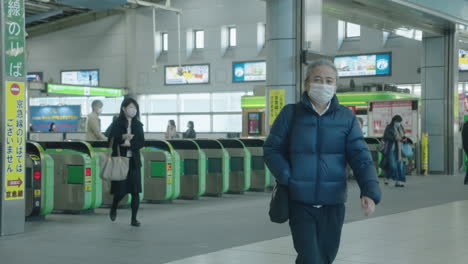 Menschen-Mit-Masken-Gehen-Durch-Fahrkartenschalter-Am-Bahnhof-Shinagawa-Jr.-In-Tokio-–-Totalaufnahme,-Zeitlupe