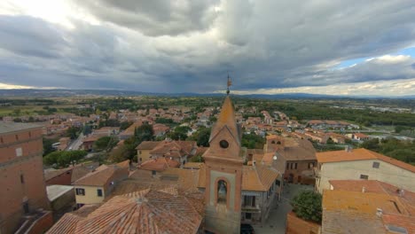 Drone-Flying-Above-Roofs-Towards-The-Church-Of-San-Cristoforo-In-Sinalunga,-Italy---aerial,-fpv