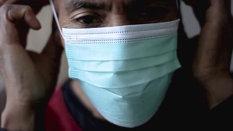 men-putting-on-a-face-mask-to-fight-the-coronavirus-on-grey-background-stock-video-stock-footage