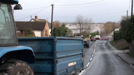 UK-February-2014---A-blue-with-a-trailer-drives-up-a-village-lane-away-from-where-rising-floodwater-has-cut-off-the-road-and-roadblock-is-in-place