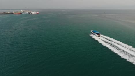 Aerial-Drone-Following-the-speed-boat-over-sea-near-the-pier