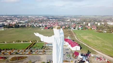 Drone-view-of-the-Christ-the-king-statue-in-Swiebodzin,-Poland,-Europe-with-the-town-in-the-background