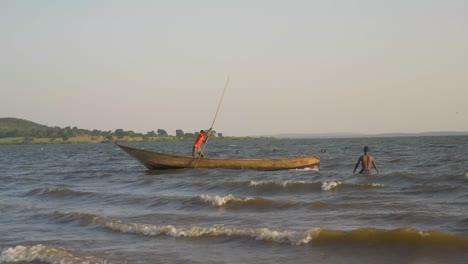 Weitwinkelaufnahme-Eines-Windigen-Victoriasees-Mit-Schwimmern-Und-Fischern-In-Traditionellen-Booten-Zwischen-Den-Wellen