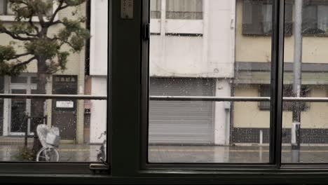 Vista-Desde-El-Tranvía-Japonés-Hasta-La-Lluvia-Afuera-Con-Gente-Caminando