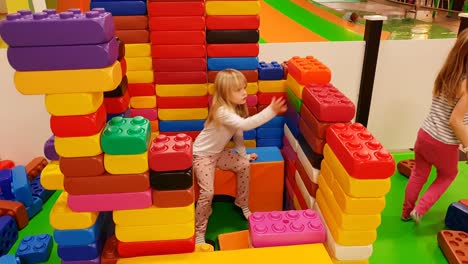 Kinder-Bauen-Ein-Großes-Schloss-Aus-Großen-Farbigen-Legosteinen,-4K-Statik