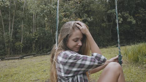 Slow-motion-girl-posing-on-swing-in-forest-in-Hawaii