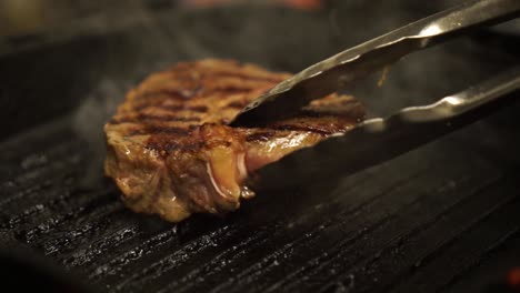 Nahaufnahme---Ein-Steak-Auf-Dem-Grill-Umdrehen