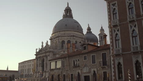 Basilica-di-Santa-Maria-della-Salute-on-a-beautiful-sunny-morning,-Seagull-flying-over,-Venice,-Italy