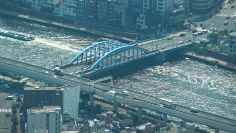 Aerial-view-of-Tokyo-river-and-ferry-crossing-under-the-bridge-from-Skytree-tower