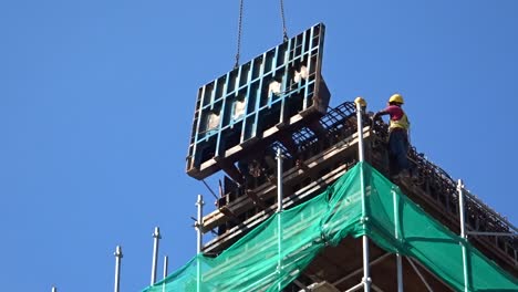 Construction-workers-working-at-height-installing-reinforcement-bar-and-form-work-at-the-construction-site
