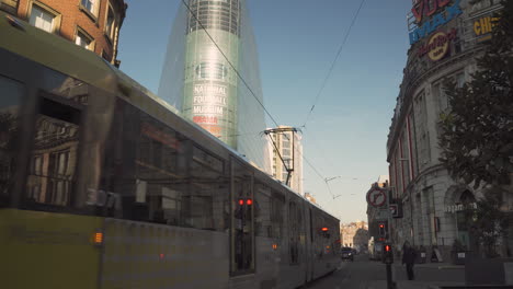 Tram-passes-by-the-National-Football-Museum-in-Manchester-City,-UK-4K
