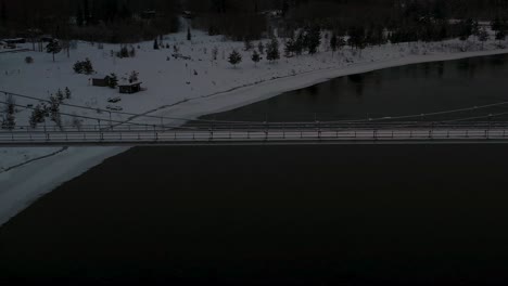 Aerial-view-of-suspension-bridge-over-dark-black-river